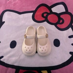 Cute white look-a-like crocs with checkered flower charm. Size 6